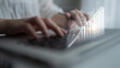 © InfiniteFlow - A focused individual types on a laptop, while a financial growth chart overlays the scene, symbolizing data-driven decisions in a modern workspace. Impute