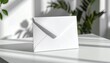 © HiSembiring - Elegant white envelope on a bright table bathed in sunlight, perfect for invitations, announcements, or heartfelt letters in a modern setting