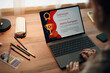 © DragonImages - Caucasian teenager girl sitting at desk using laptop, viewing digital certificate of appreciation on screen, hands on keyboard, pencil case and notebook nearby, engaging in academic activity