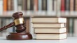 © oksa_studio - Wooden gavel rests next to a stack of legal books, symbolizing law, justice, and courtroom proceedings, with copy space
