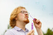 © Voyagerix - Man blowing soap bubbles, having fun