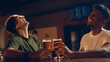 © master1305 - Friends laughing together while holding beer glasses at bar table. Concept of nightlife imagery, bar lifestyle promotion, brewery marketing, beverage advertising.