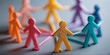 © sornram - Colorful paper figures holding hands, symbolizing unity, diversity, and social connection in a community setting.