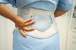 © Warawan - Asian senior pain back wearing elastic support belt with walker.