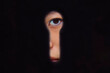© Connect Images - A young woman's eye visible through a dark keyhole, creating a mysterious and curious look. Shanghai, China