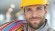 © Tmack - Skilled electrician with bright blue eyes carries colorful wires ready for industrial project success