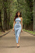 © Andrey_Arkusha - Young beautiful brunette woman in blue knitted dress posing in summer park