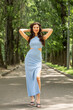 © Andrey_Arkusha - Young beautiful brunette woman in blue knitted dress posing in summer park