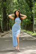 © Andrey_Arkusha - Young beautiful brunette woman in blue knitted dress posing in summer park