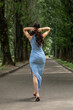 © Andrey_Arkusha - Young beautiful brunette woman in blue knitted dress posing in summer park