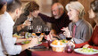 © JackF - Family celebration. Multinational family eats in restaurant, socializes, drinks wine. Family holiday is excuse to meet.
