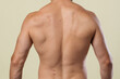 © skeronov - Body parts: a man's athletic back after active exercise. The result of diets and a healthy lifestyle. A fitness model on a yellow background.