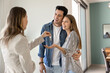 © fizkes - Young newlywed couple receives keys from real estate agent