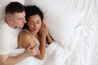 © New Africa - Lovely couple lying in bed at home, top view