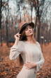 © Тамара Печеная - Young woman enjoying a serene moment in a fall forest with orange leaves on the ground