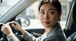 © antuanetto - Young Asian woman driving a car and looking over her shoulder