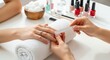 © mh - Manicurist filing client nails on towel in beauty salon with nail polish bottles.
