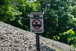 © Trinitro - No trespassing sign warns of dangers on private property in wooded area during sunny day