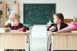 © Pixel-Shot - Classmates with school cones sitting at desks in classroom