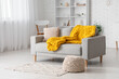 © Pixel-Shot - Modern interior of living room with stylish grey sofa, pouf and yellow knitted plaid