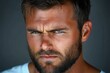 © zhuan - Close-up portrait of a man with blue eyes and thick beard showing intense, serious, and focused facial expression against a dark blurred background