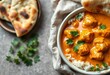 © Pimchada - Creamy, orange butter chicken curry in a bowl with naan bread,  dinner,   mild