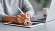 © GlimmerPixel - Woman using a stylus to write on a tablet