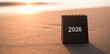 © maybeiii - Close up 2026 desk calendar on the beach in the sunset time. Resolution, Goal, Action, Planning, and manage to success business.