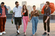 © Bliss - Young friends enjoying a lively rooftop party as the sun sets over the city skyline
