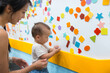 © leungchopan - Mother and baby playing with magnets on whiteboard at playhouse