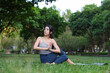 © leungchopan - Woman practicing yoga exercise outdoors at green park