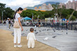 © leungchopan - Young mother carrying baby to see birds in park