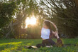 © leungchopan - Woman practicing yoga outdoors in sunlight