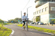 © leungchopan - Young woman cycling on road outside in park