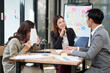 © aekachai - Group of Asian businesspeople sits down for a business investment planning meeting.