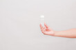 © Rifqi Muflih - Hand holding small bottle for medical or beauty purposes against plain background
