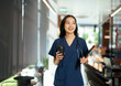 © PaeGAG - Female nurse walking with coffee and tablet