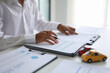 © Supitnan - A man signing a contract for a car loan, lease, vehicle registration or insurance policy. Concept for Sales Contract, Financing Agreement, Insurance Policy, Vehicle Registration.