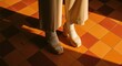 © Ari - Fashionable footwear and trousers on a tiled floor overhead sunlight