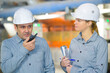 © auremar - male supervisor using walkie-talkie with female colleague