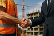 © Mariia - Business handshake between a construction worker and an executive at a building site, symbolizing partnership, investment, and successful project collaboration