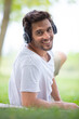 © auremar - man relaxing listen to music with headphones in park