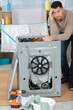 © auremar - concept man stressed next to washing machine
