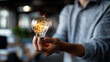 © Kateryna - Idea innovation inspiration concept with hand holding illuminated device faceless man defocused background creativity with illumination glitter sustainable business