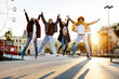 © Xavier Lorenzo - Happy young friends jumping together holding hands in Barcelona, enjoying winter vacation in the city