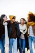© Xavier Lorenzo - Diverse group of young friends having fun together outdoors on winter. Millennial student people laughing walking in city street enjoying day off. Youth community and friendship concept.