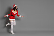 © New Africa - Beautiful woman in Mrs Claus costume on gray background, space for text. Christmas season