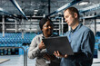 © DC Studio - Data center computer scientists doing brainstorming, using laptop to manage system stability. Server room colleagues optimizing performance with device, configuring equipment