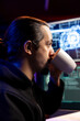 © DC Studio - Hacker in secret lair drinking coffee, using AI to break into secure computer systems and bypass security. Man enjoying beverage, using deep learning to attack weak spots in company networks