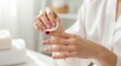 © Olga Ко - Close-up of female hands removing nail polish with a white cotton pad in a spa atmosphere, hand care concept
